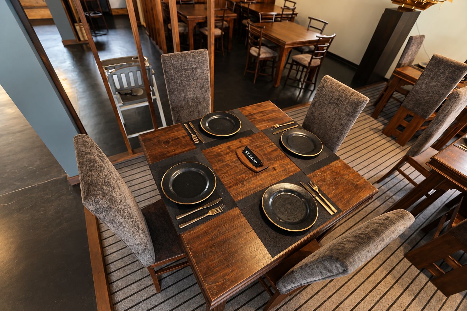 Un comedor con una mesa rectangular dispuesta para cuatro personas, rodeada de sillas tapizadas.