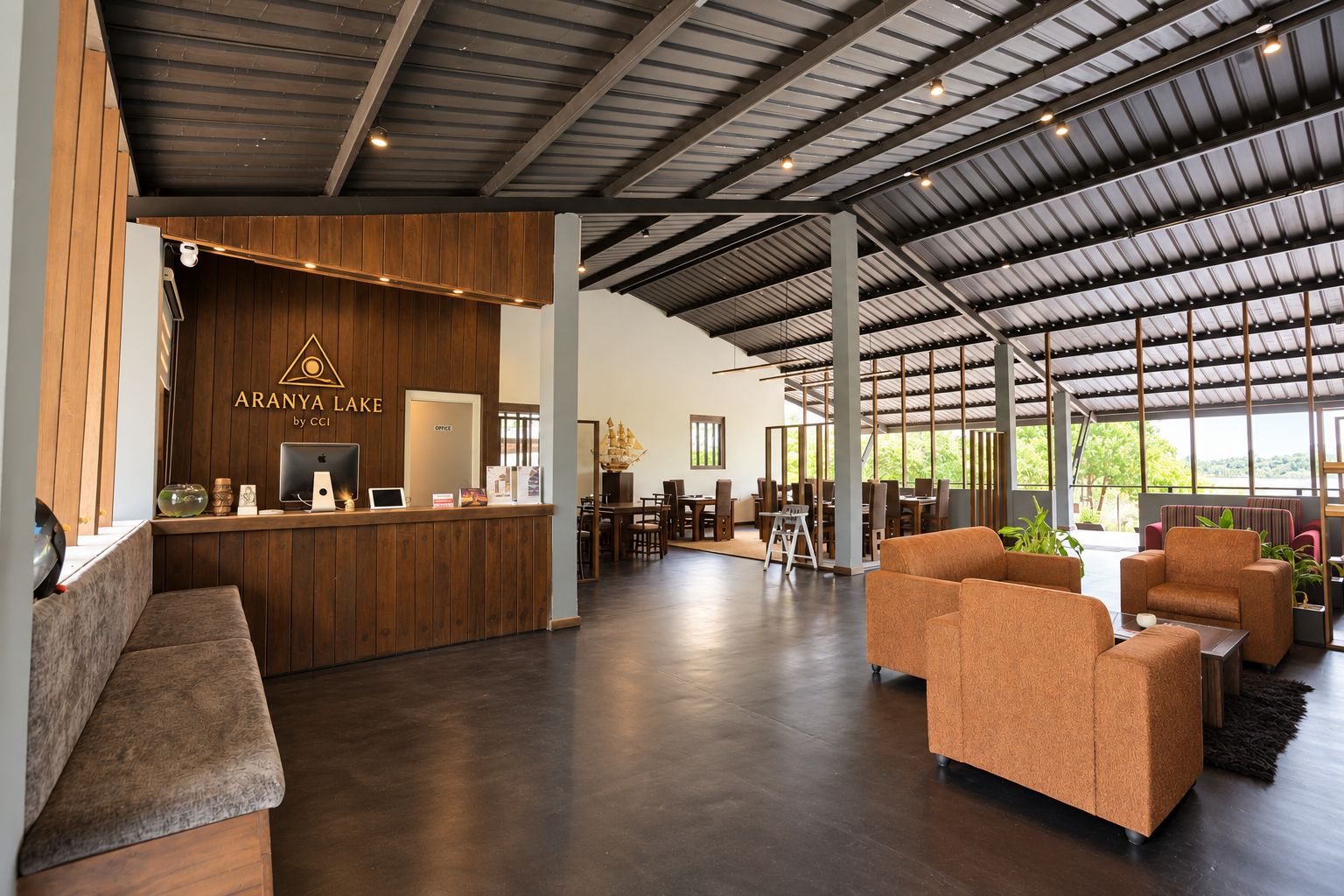 A spacious lobby with a reception desk, seating area, and large windows.