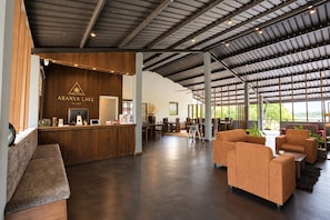 Eine geräumige Lobby mit einer Rezeption, einer Sitzecke und großen Fenstern.