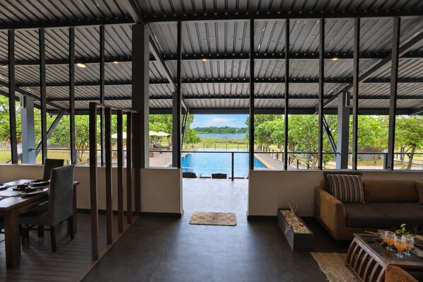 Amplio espacio interior con vista a la piscina, zona de comedor y sala de estar con vistas.