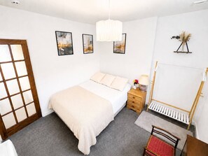 Une chambre à coucher avec un lit, une table de chevet, une lampe et un piano droit.