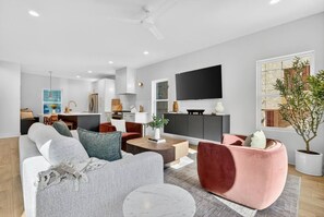Ein modernes Wohnzimmer mit einer Couch, einem Couchtisch und einem Fernseher.