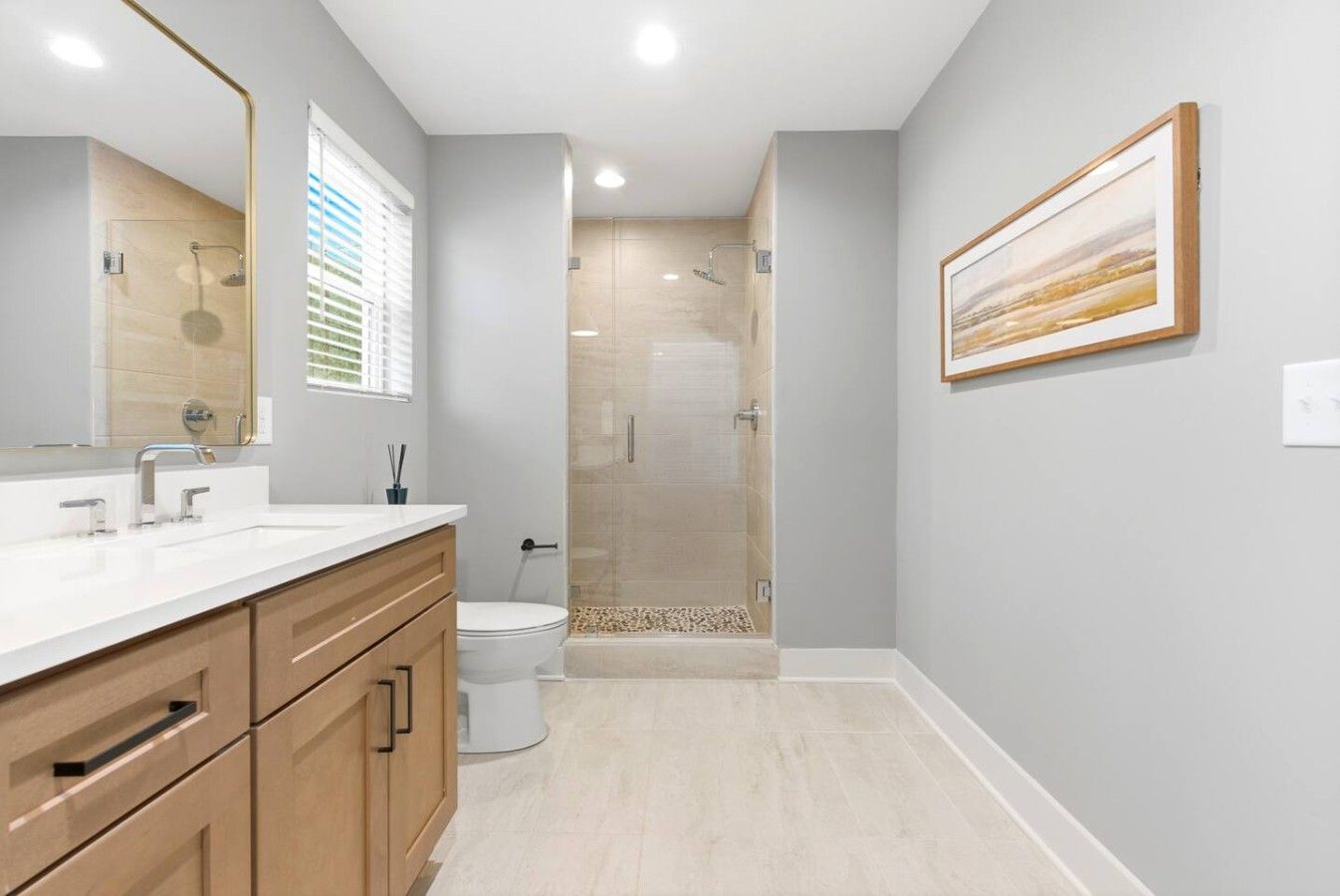 A modern bathroom with a shower, toilet, and vanity.