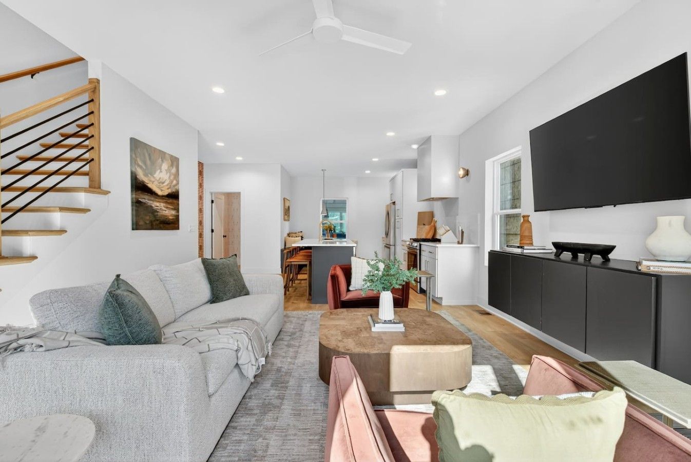 A modern living room with a sofa, coffee table, and a TV mounted on the wall.