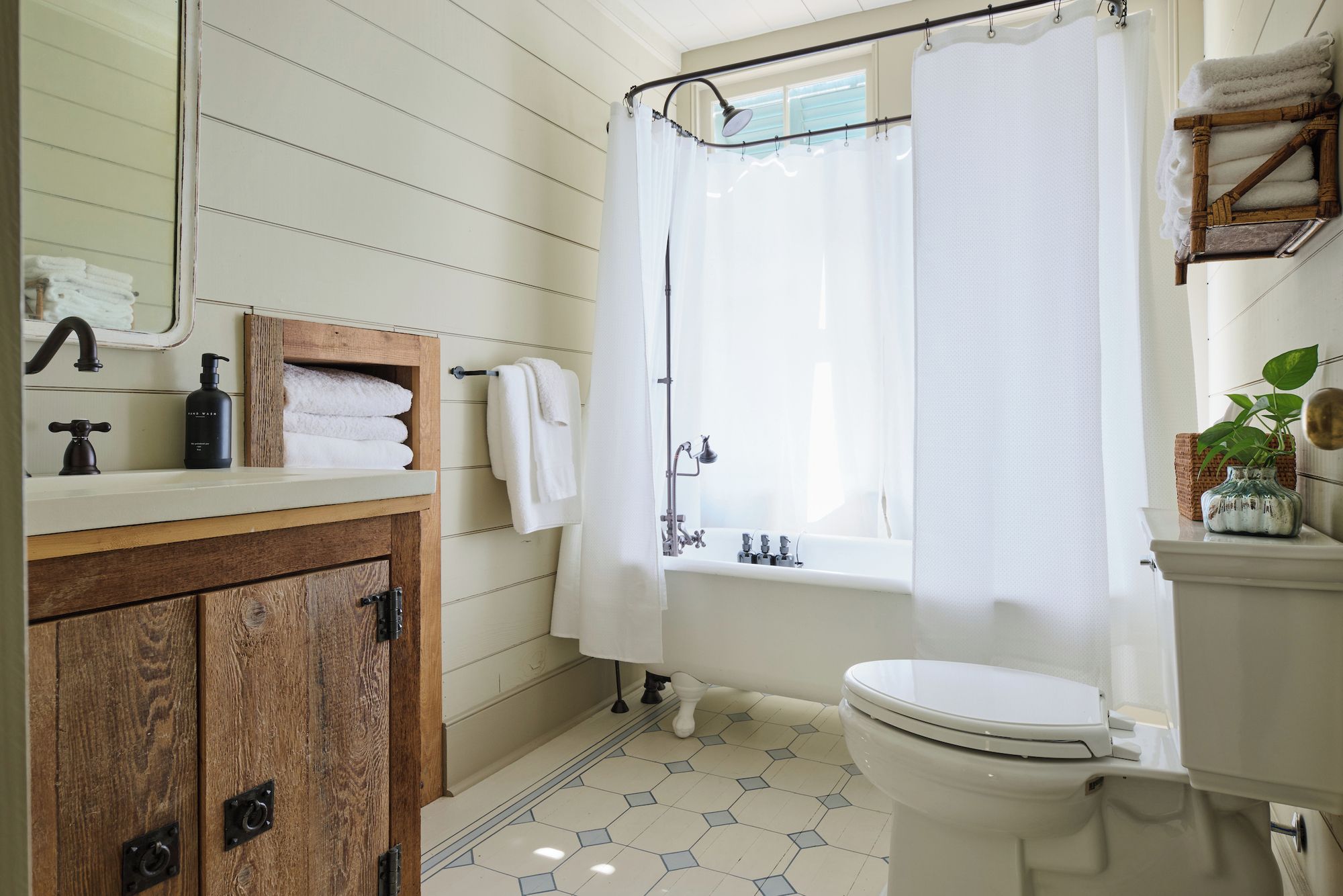 A bathroom with a wooden vanity, a bathtub, and a toilet.
