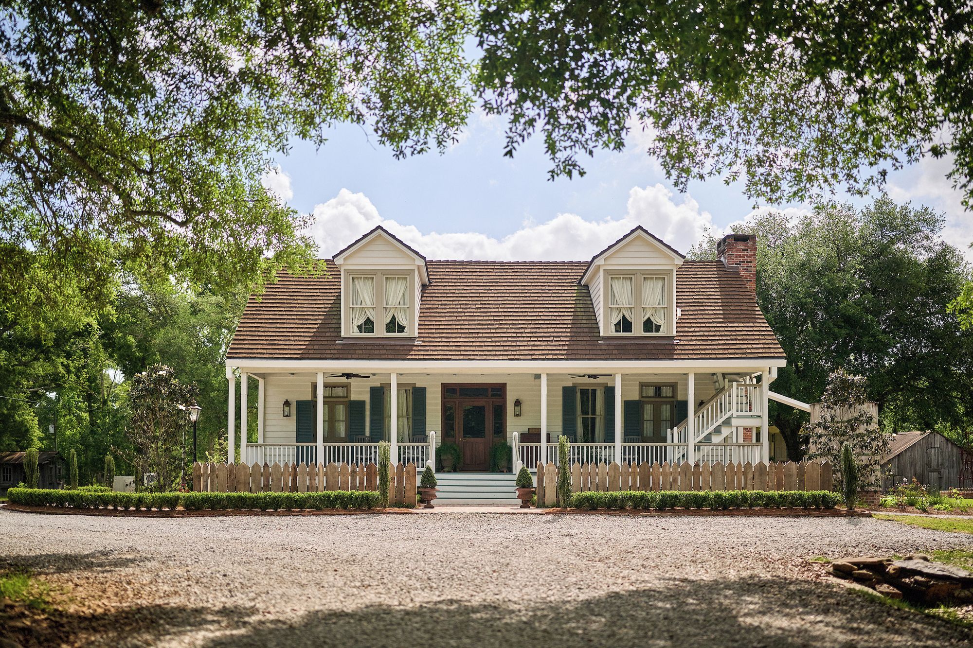 A two-story house with a porch, a front entrance, and a small front yard.