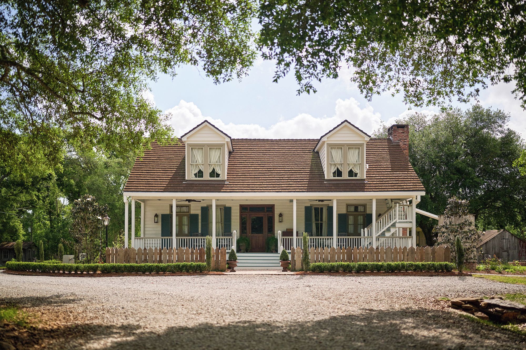 A two-story house with a porch, a front door, and a small front yard.