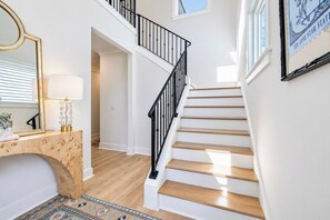 Eine Treppe mit schwarzer Geländer und Holzboden, die zu einer oberen Etage führt.