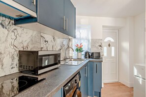 A modern kitchen with a built-in microwave, a sink, and a dishwasher. - Host Stay Poplar Apartment (Rochester)