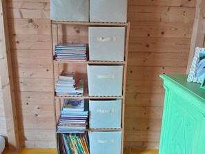 Una estantería de madera con cajas de almacenamiento y libros.