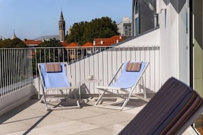 A balcony with two sun loungers, a small table, and a white railing. - Vila Catarina Luxury Apartments: Superior Apartment with Private Terrace (Porto)