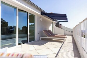 A modern balcony with two lounge chairs and a retractable awning. - Vila Catarina Luxury Apartments: Premium Apartment with a Private Terrace (Porto)