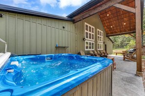 A hot tub with a wooden deck, outdoor seating, and a covered area with a view of the surrounding landscape. - Branson Lodge, Hot Tub, 6 King Rooms, 2 Bunk Rooms (Branson)
