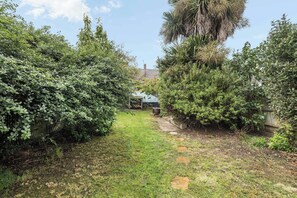 Ein Gartenweg führt zu einem Gebäude mit einem sichtbaren Schornstein.