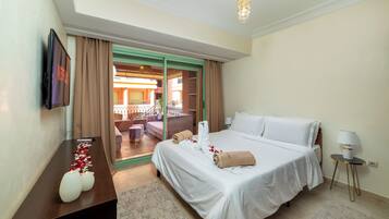 Une chambre d’hôtel avec un lit, un bureau, une télévision et une vue sur l’extérieur.