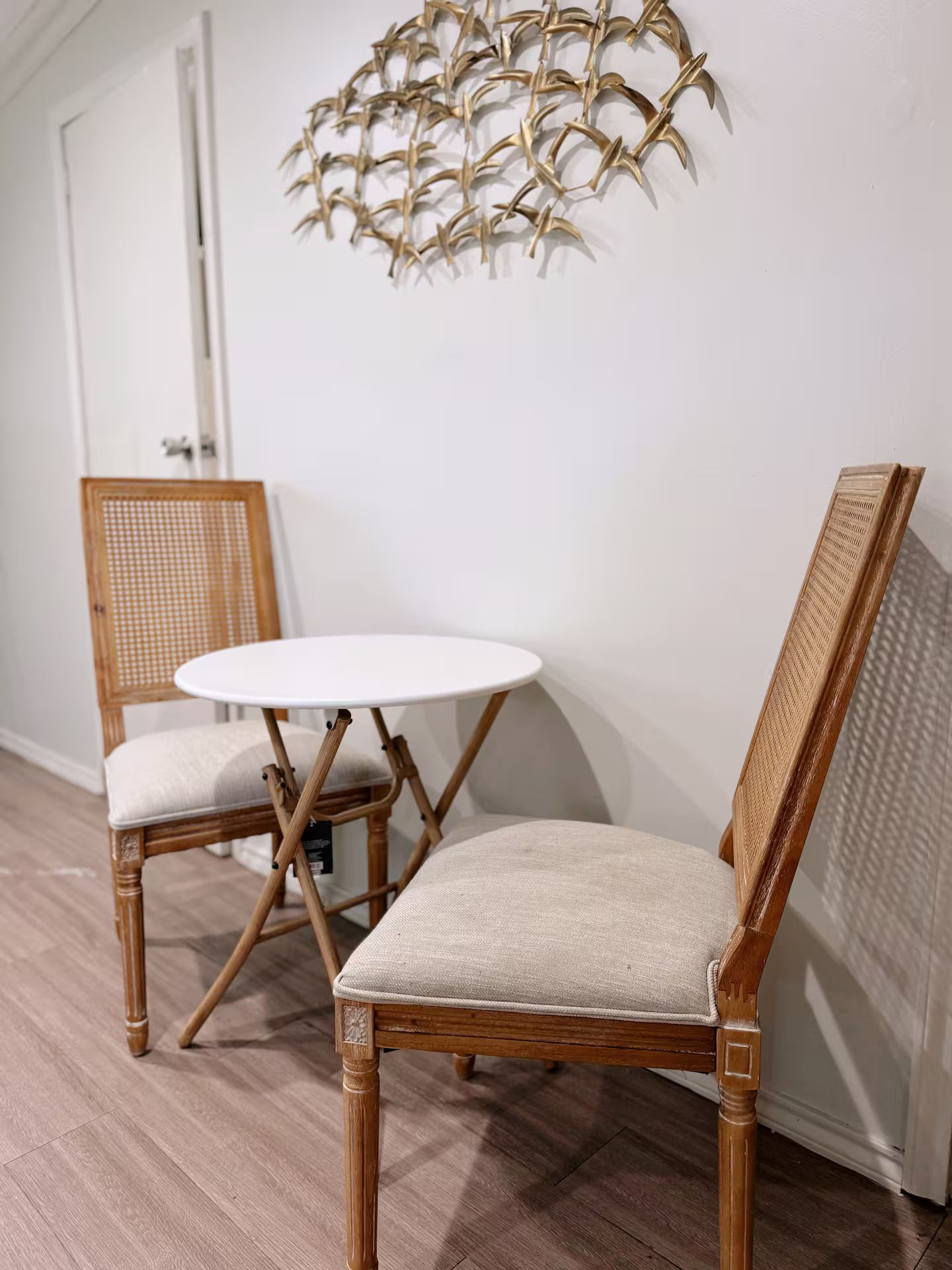 A room with two wicker chairs and a small round table.