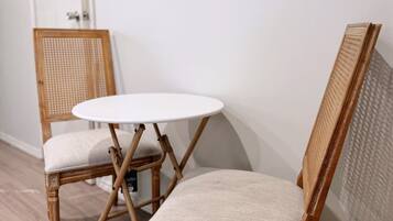 A room with two wicker chairs and a small round table.