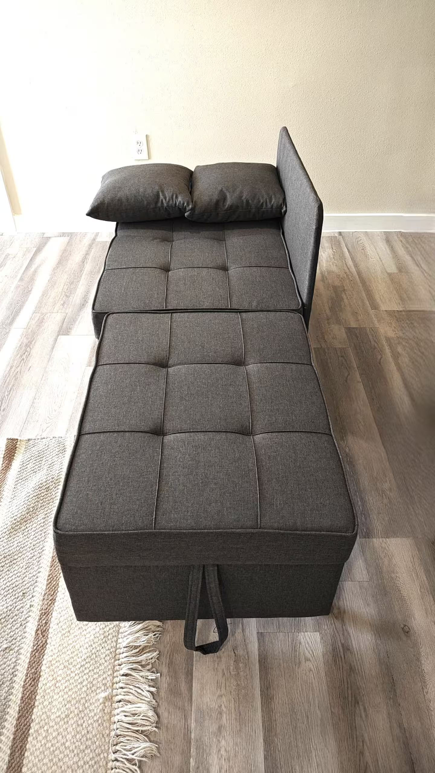Un lit avec une tête de lit, un oreiller et une couverture.