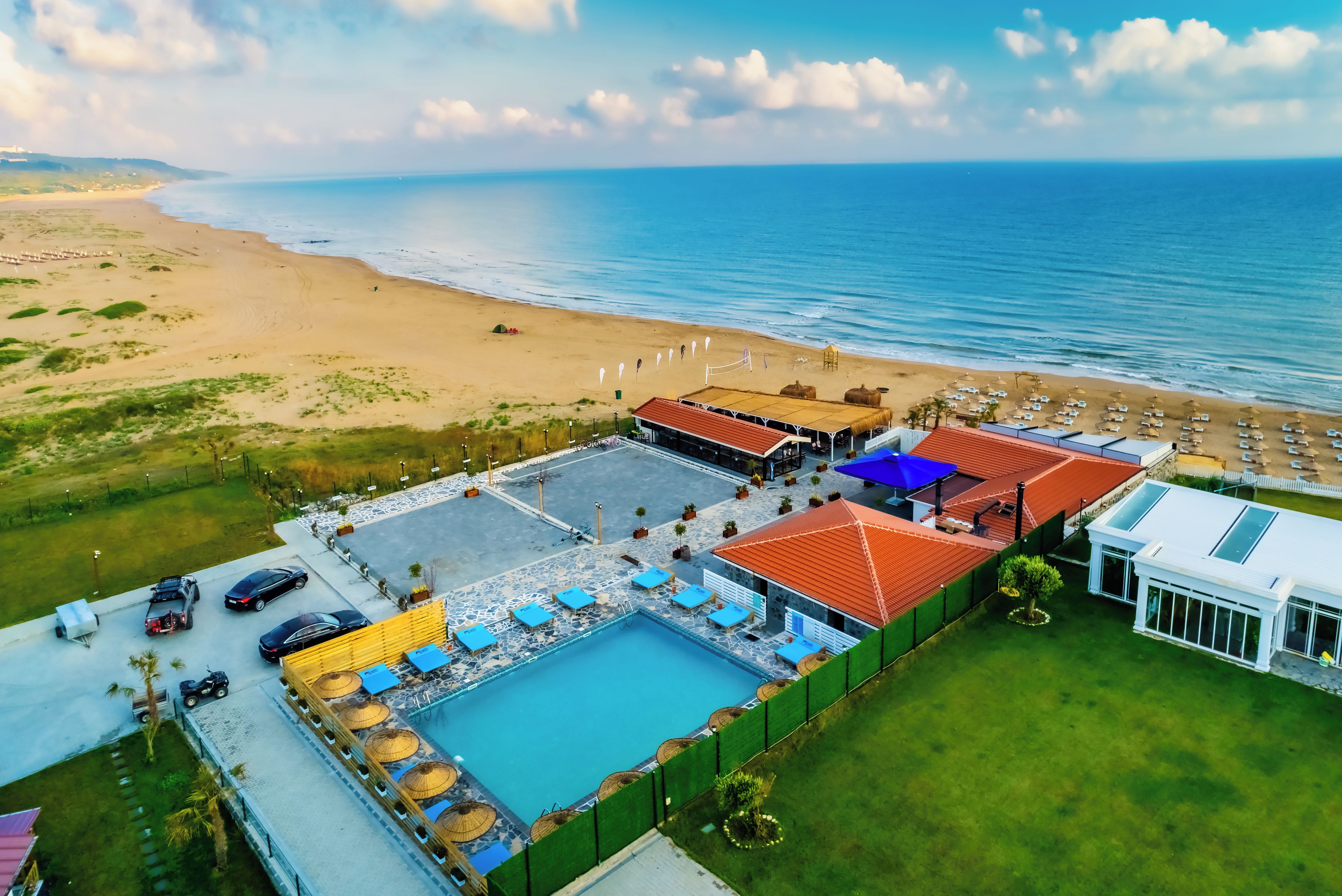 Vista aérea de un resort con piscina, playa y océano.