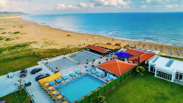 Vista aérea de un resort con piscina, playa y océano.