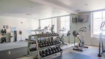 A gym with weightlifting equipment, treadmills, and exercise bikes.