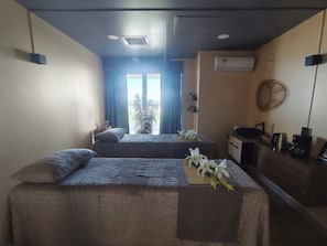 A hotel room with two beds, a desk, and a view of the outdoors. - Ocean View | Pool, sauna and more | 2 minutes from the airport | Suite (Cartagena de Indias)
