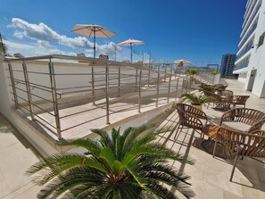 A rooftop terrace with outdoor seating, a staircase, and a view of the city skyline. - Ocean View | Pool, sauna and more | 2 minutes from the airport | Suite (Cartagena de Indias)