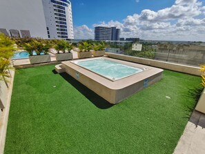 A rooftop swimming pool with artificial grass, surrounded by planters and buildings in the background. - Ocean View | Pool, sauna and more | 2 minutes from the airport | Suite (Cartagena de Indias)
