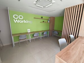 A modern office space with a green accent wall, a long wooden table, and several chairs. - Ocean View | Pool, sauna and more | 2 minutes from the airport | Suite (Cartagena de Indias)