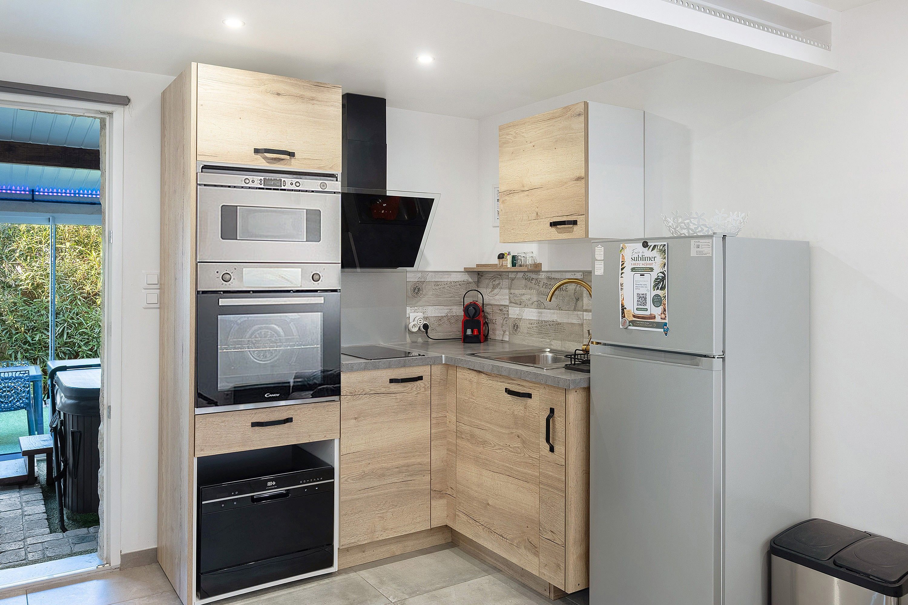 Een moderne keuken met houten kastjes, roestvrijstalen apparatuur en een inbouwoven.