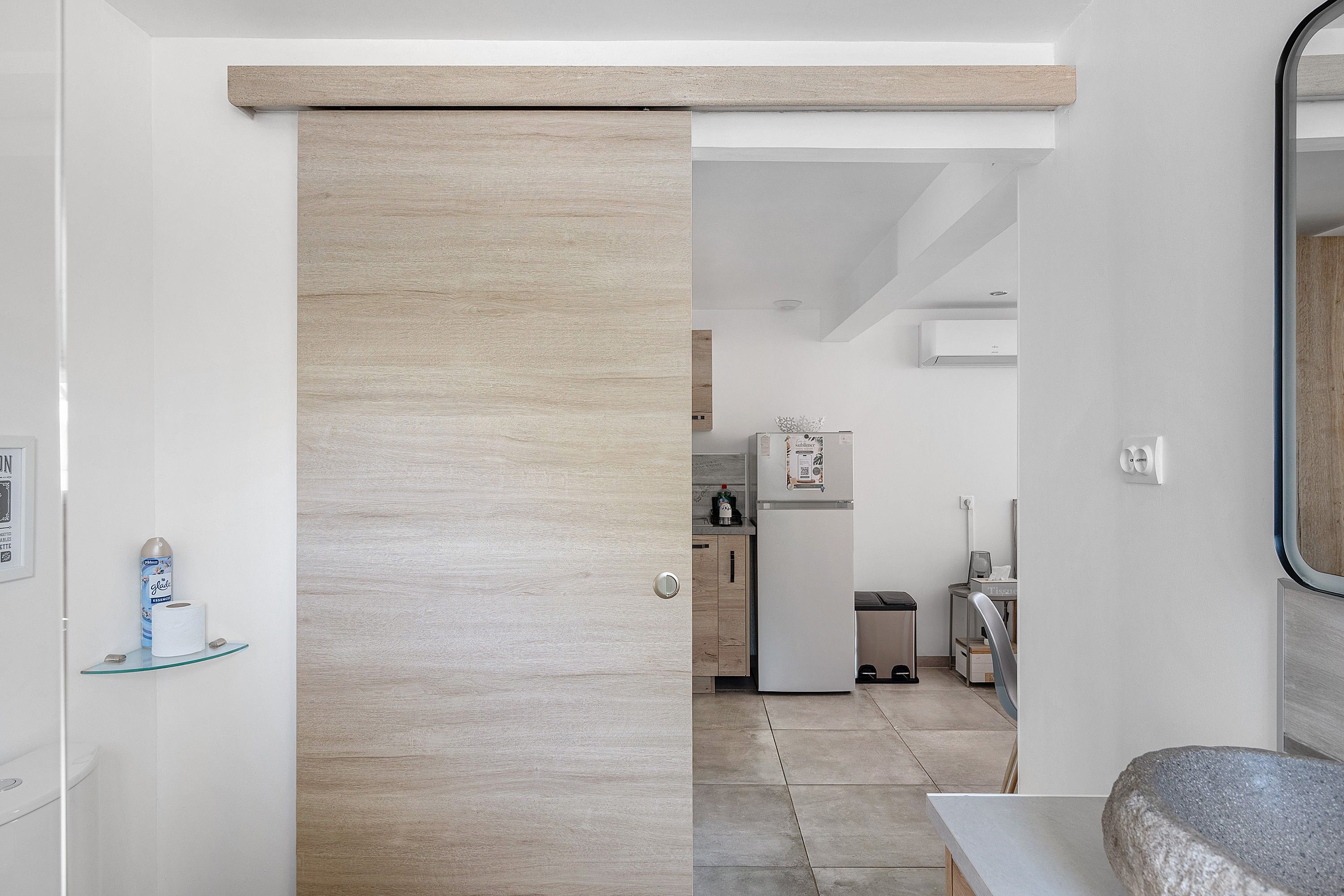 A modern kitchen with a built-in oven, a refrigerator, and a sink.