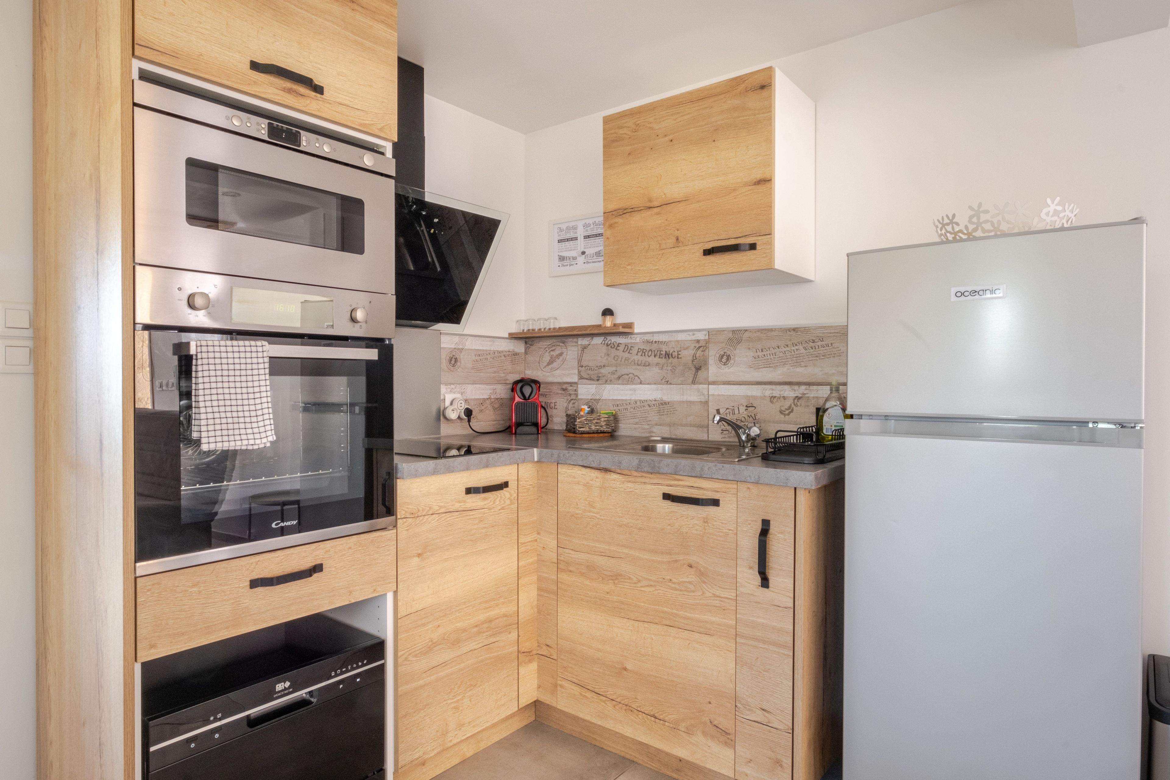 A modern kitchen with wooden cabinets, stainless steel appliances, and a built-in oven.