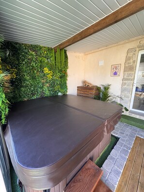 Une table de billard avec, en arrière-plan, un décor naturel de verdure et un mur en pierre.