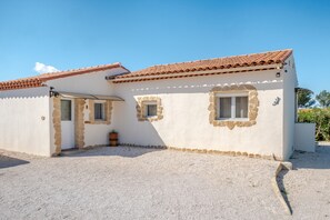 Un bâtiment à deux étages, doté d’un toit en tuiles, d’une allée gravillonnée et d’un petit jardin.