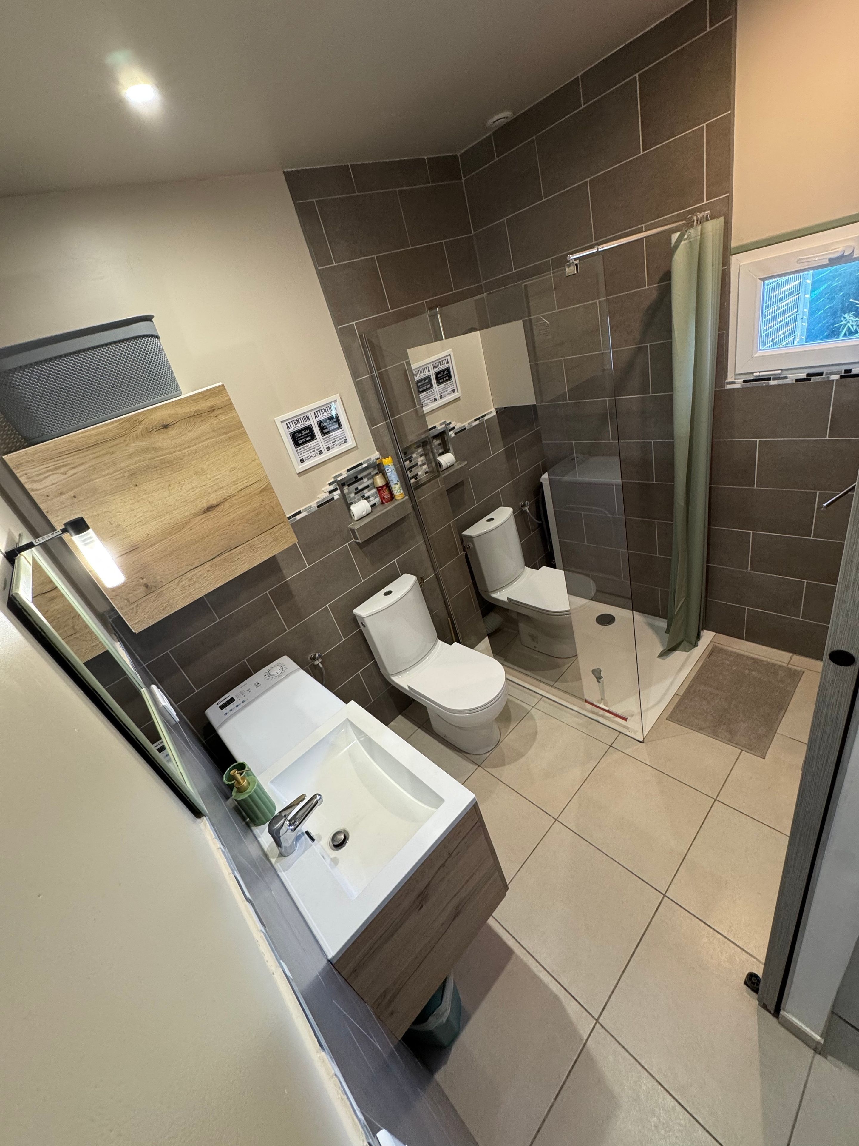 A modern bathroom with a shower, toilet, and sink.