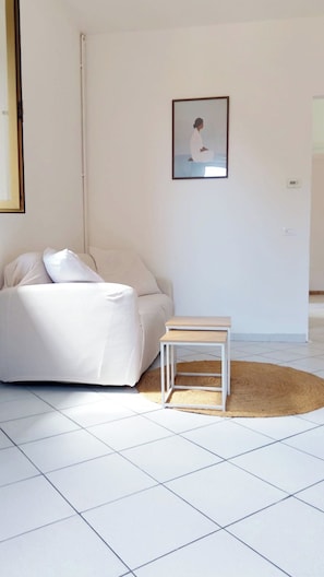 Un dormitorio minimalista con cama, mesita de noche y un cuadro en la pared.