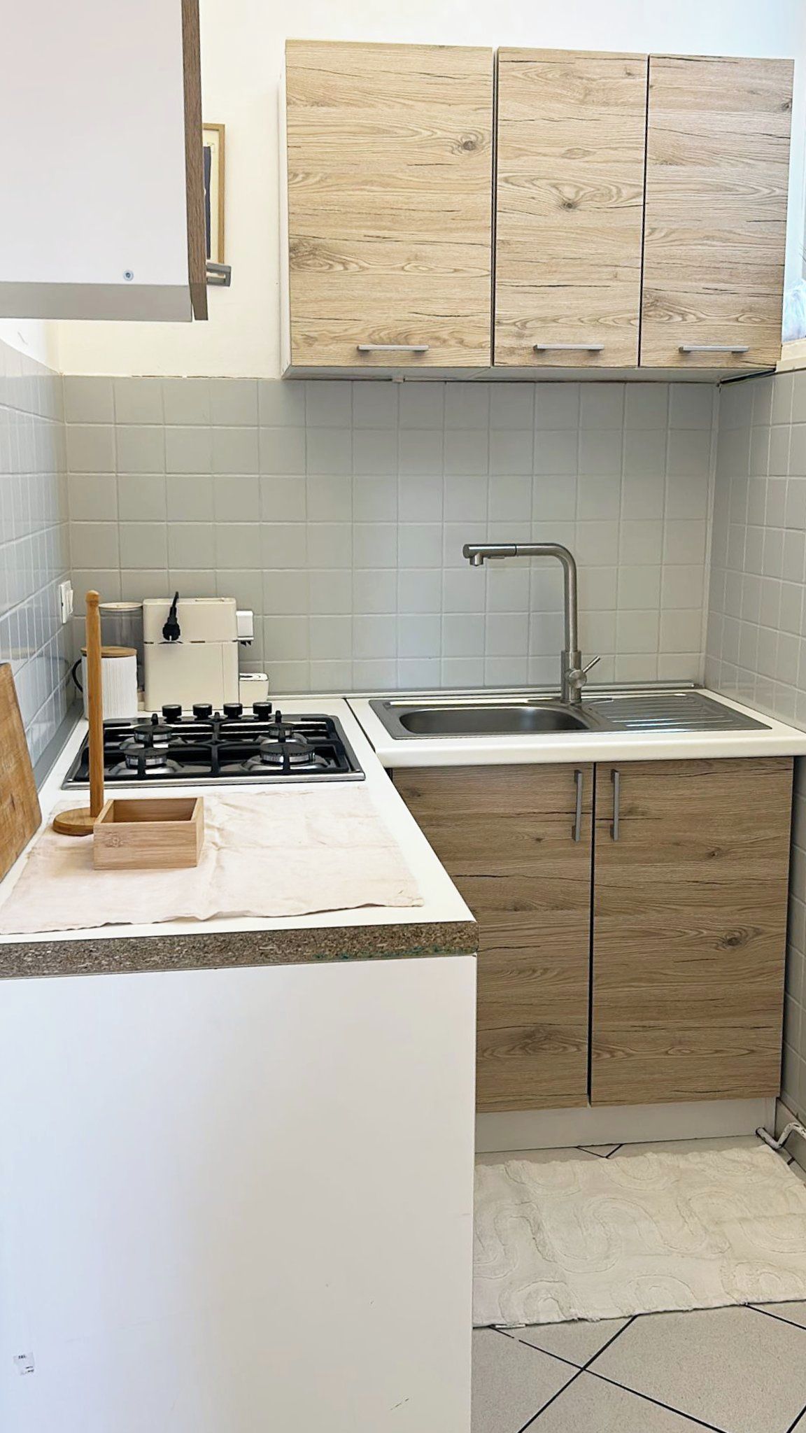 A kitchen with a gas stove, a sink, and wooden cabinets.
