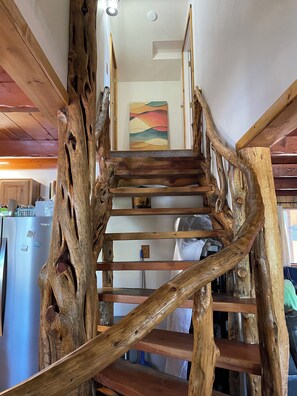 Uma escada de madeira com design rústico, que leva a um andar superior.