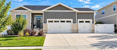 A two-story house with a garage, a front door, and a well-maintained lawn.
