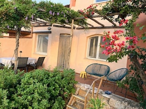 A cozy outdoor seating area with a pergola, a table, and chairs. - Beach Home in Sardegna Italy - Wake Up in Heaven! (Canneddi)