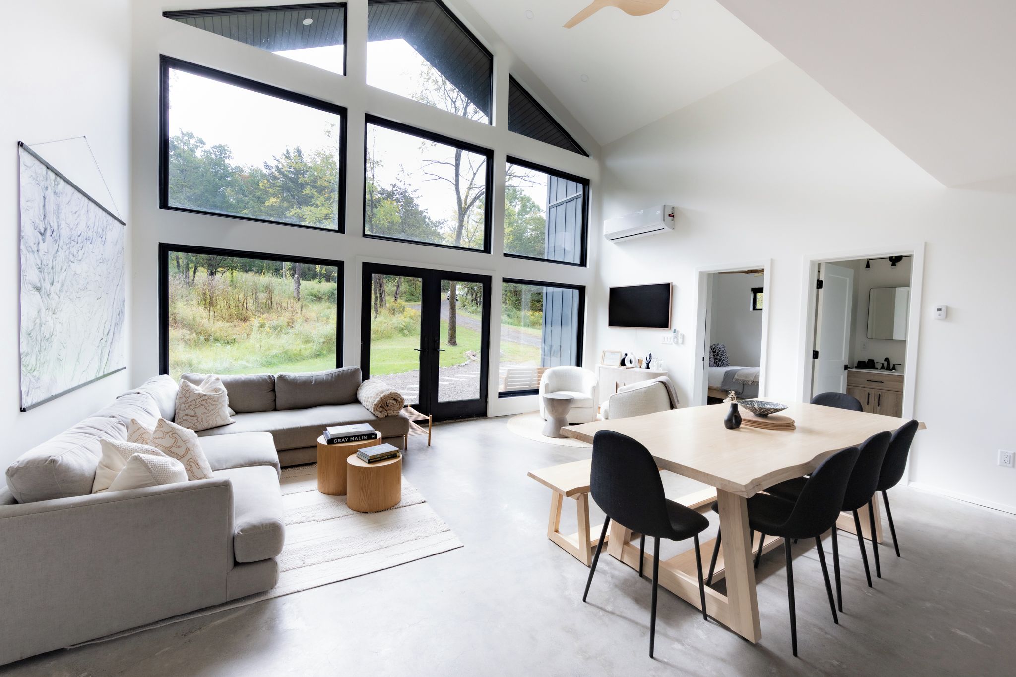 A modern living room with a sofa, coffee table, and dining table.