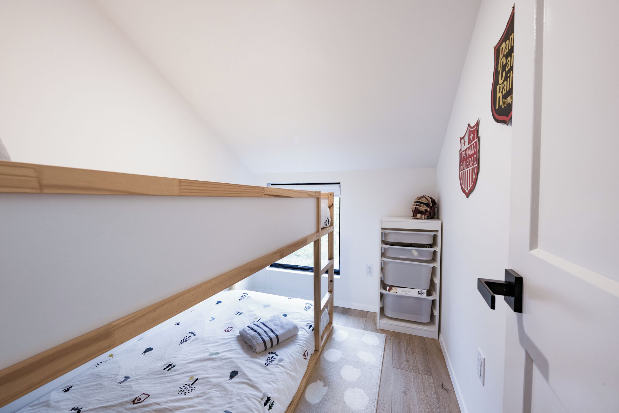 Ein Stockbett mit Fenster, Ablagefläche und einer Tür mit einem Schild.