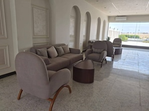 A spacious lobby with a grey sectional sofa, armchairs, and a coffee table. - Hurghada Lavanda Beach Resort (Hurghada)