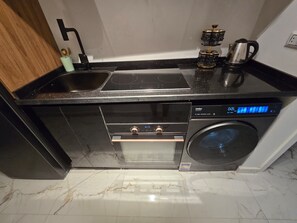A compact kitchen with a built-in oven, a dishwasher, and a coffee maker. - Hurghada Lavanda Beach Resort (Hurghada)