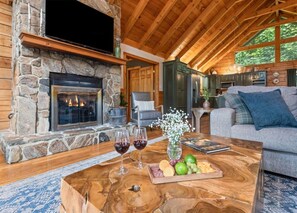 A cozy living room with a stone fireplace, wooden ceiling, and a comfortable seating area. - ROCKY TOP RETREAT - Perfect for Skiers and Holiday Travelers (Maggie Valley)