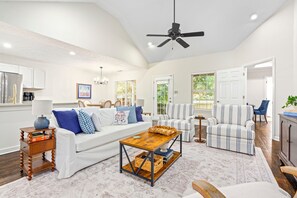 A spacious living room with a white sofa, striped armchairs, a wooden coffee table, and a ceiling fan. - New! 3BR/2BA House - 0.8 Mi From Downtown Auburn (Auburn)