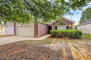 A residential house with a garage, a brick exterior, and a well-maintained lawn. - New! 3BR/2BA House - 0.8 Mi From Downtown Auburn (Auburn)