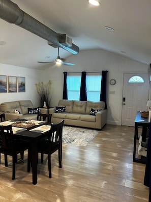 A living room with a sofa, dining table, chairs, and a ceiling fan. - Chasing Sunsets
Cozy 1-bedroom  2 bath  with 2 beds and All new furnishings. (Galveston)