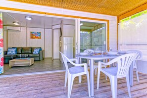 A dining area with a table and chairs, a refrigerator, and a sofa in the background. - Ô ti Zagaya - Clim - Piscines et plage (Le Vauclin)