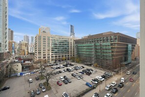 A parking lot with multiple cars, surrounded by buildings with modern architecture. - Stylish Studio, Steps to Yonge-Dundas Square | Parking Available (Toronto)